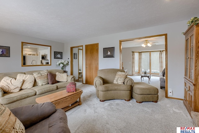 living room with a textured ceiling, baseboards, and carpet flooring