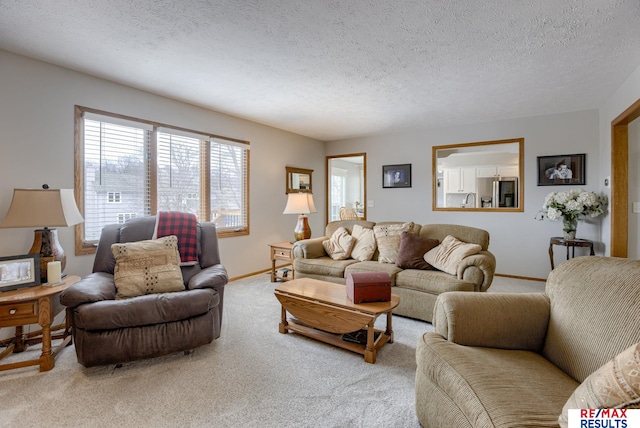 living area with a textured ceiling, carpet floors, and baseboards