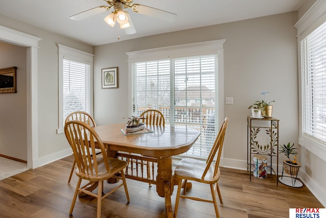 dining room featuring a ceiling fan, baseboards, and wood finished floors