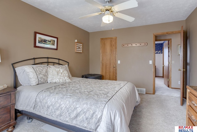 bedroom with visible vents, light carpet, ceiling fan, a textured ceiling, and baseboards