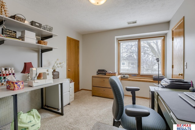 office space with light carpet, a textured ceiling, visible vents, and baseboards