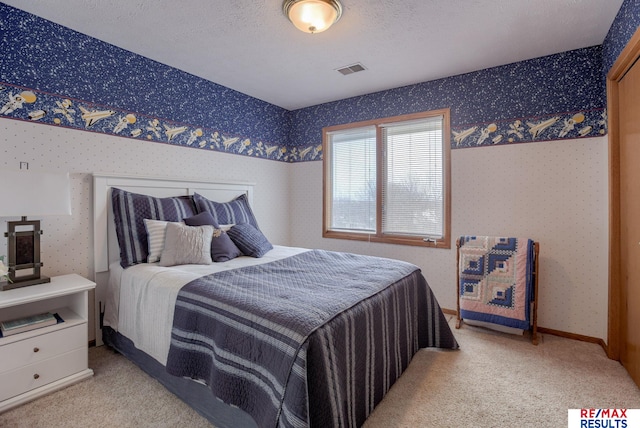 carpeted bedroom featuring baseboards, a textured ceiling, visible vents, and wallpapered walls