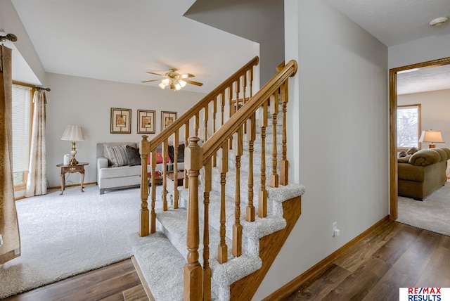 staircase with a ceiling fan, baseboards, and wood finished floors