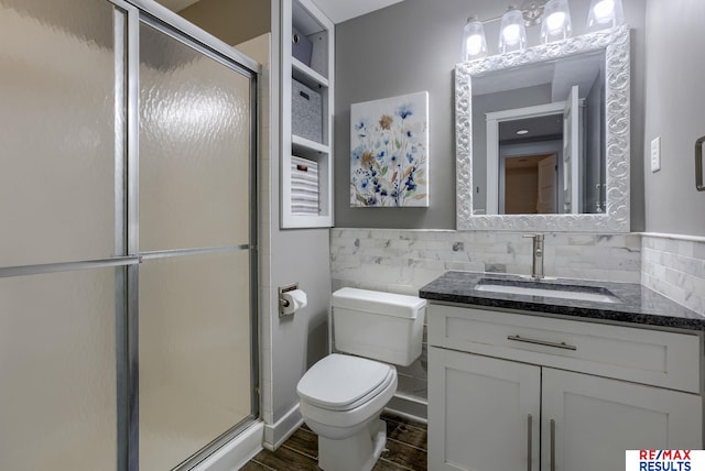 full bath featuring toilet, a stall shower, tile walls, and vanity