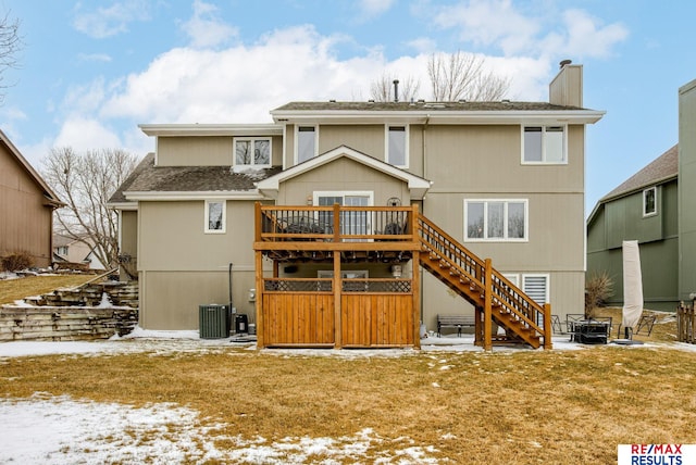 snow covered rear of property with a patio, a chimney, stairway, a wooden deck, and central air condition unit