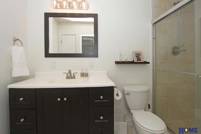 bathroom featuring tiled shower, vanity, and toilet