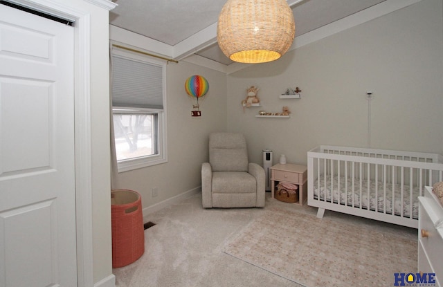 bedroom featuring a crib, carpet, and baseboards