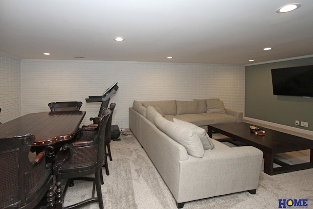 living room with light carpet, baseboards, brick wall, crown molding, and recessed lighting