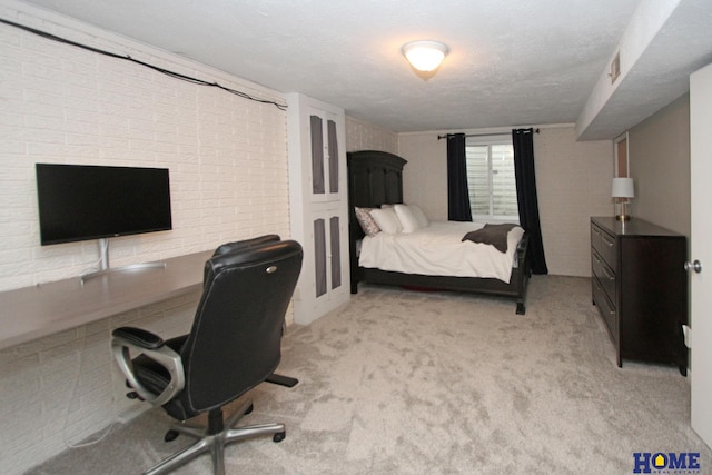 bedroom with a textured ceiling, brick wall, visible vents, and light colored carpet