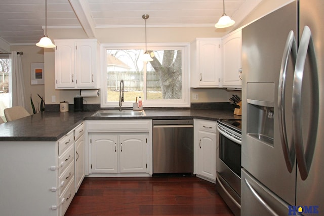 kitchen with stainless steel appliances, dark countertops, a sink, and a peninsula