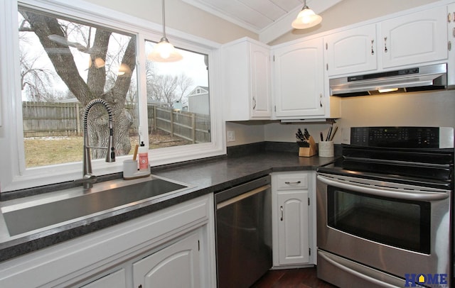 kitchen featuring dark countertops, appliances with stainless steel finishes, white cabinets, a sink, and under cabinet range hood