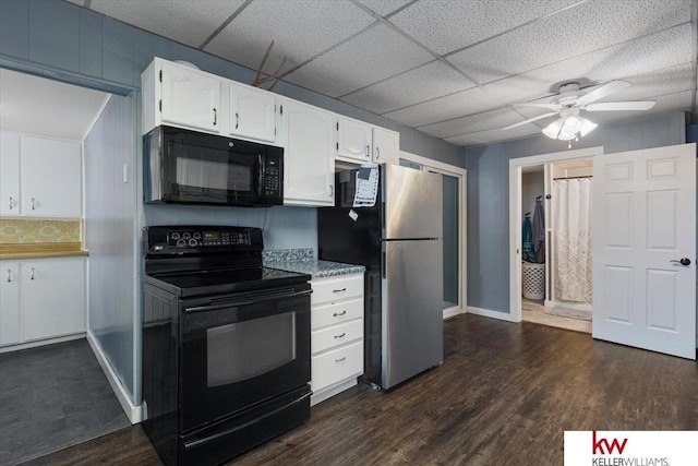 kitchen with black appliances, dark wood-type flooring, a drop ceiling, and white cabinetry