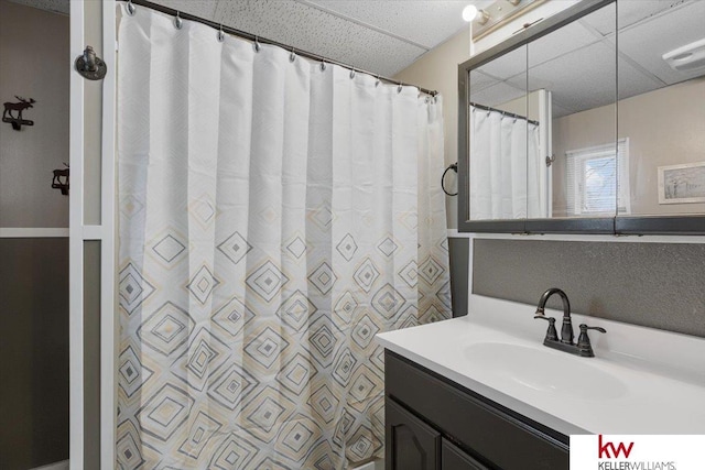 full bathroom with a paneled ceiling and vanity