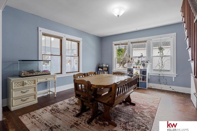 dining space with baseboards and wood finished floors