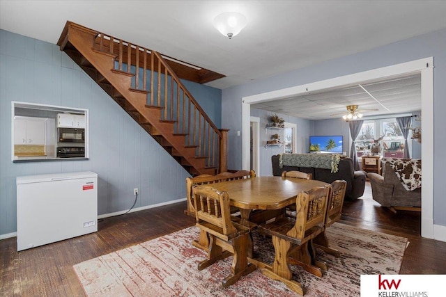 dining room featuring a ceiling fan, baseboards, stairway, and wood finished floors