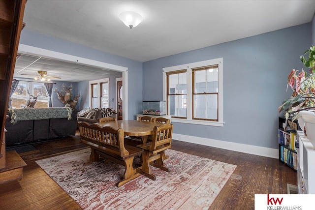 dining space featuring wood finished floors, a ceiling fan, and baseboards