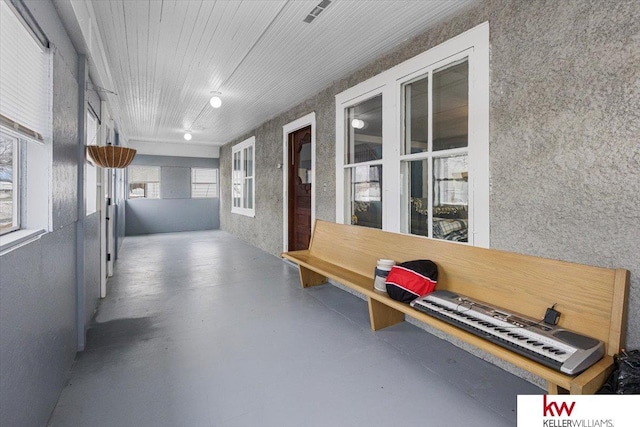 hallway with concrete floors and visible vents