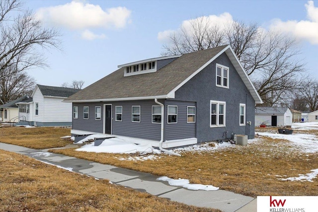 view of front of house with a shingled roof and central AC unit