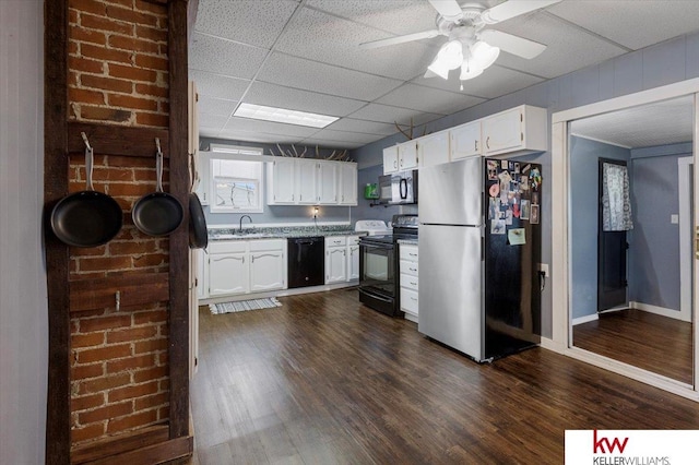 kitchen featuring dark wood-style flooring, white cabinets, a sink, a drop ceiling, and black appliances