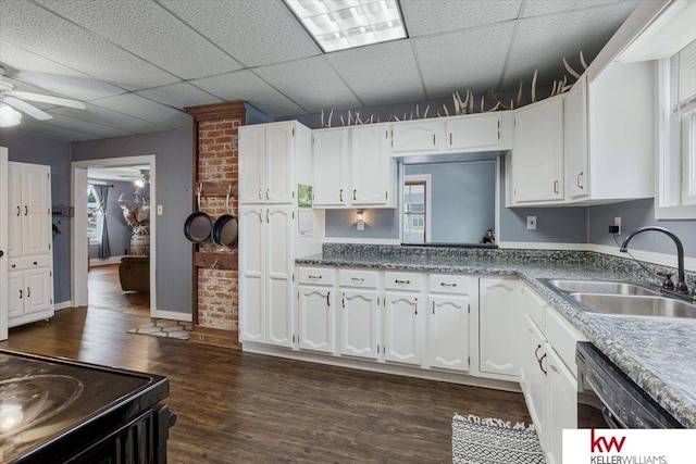 kitchen featuring a paneled ceiling, a sink, a ceiling fan, white cabinetry, and dark wood finished floors