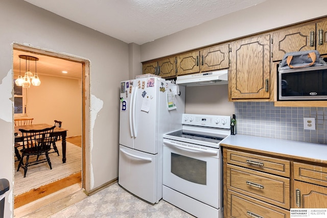 kitchen featuring white appliances, decorative backsplash, brown cabinetry, light countertops, and under cabinet range hood