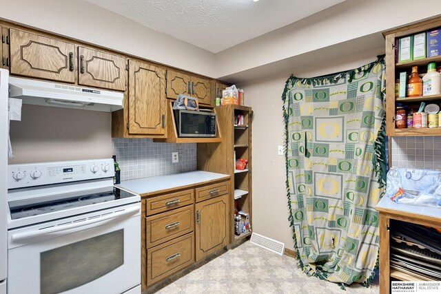 kitchen with light countertops, stainless steel microwave, electric range, backsplash, and under cabinet range hood