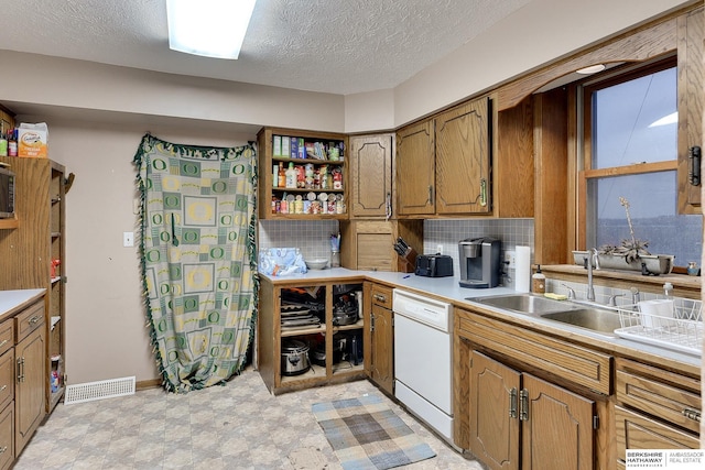 kitchen with visible vents, dishwasher, light floors, open shelves, and a sink