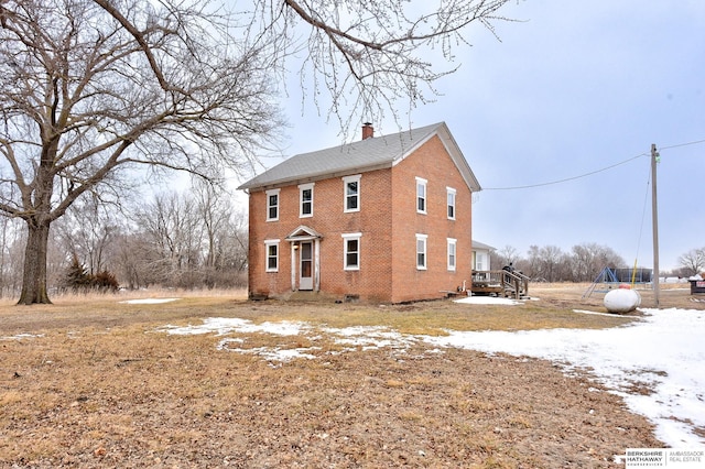 view of home's exterior featuring brick siding and a chimney