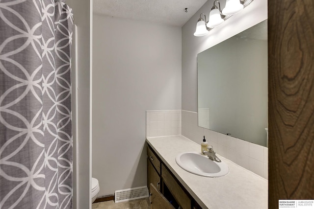 full bath with a textured ceiling, curtained shower, toilet, visible vents, and vanity