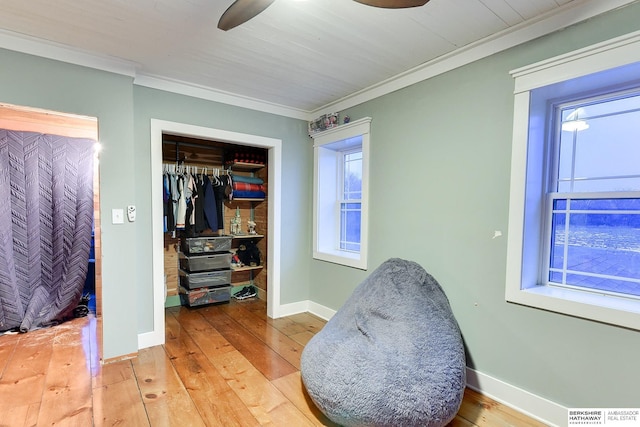 bedroom featuring ornamental molding, a closet, baseboards, and hardwood / wood-style floors