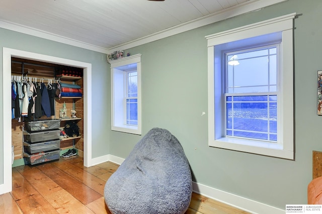 interior space featuring baseboards, a closet, ornamental molding, and hardwood / wood-style floors