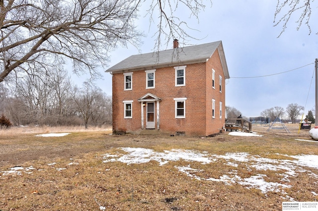 rear view of property with brick siding and a chimney