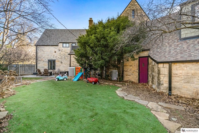 view of yard with a playground, a patio, and fence