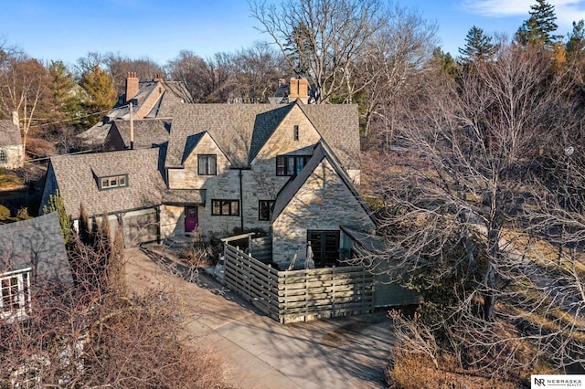 view of front of property with stone siding and fence