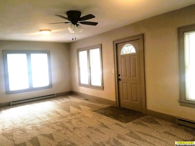 foyer entrance featuring baseboards, light carpet, and baseboard heating