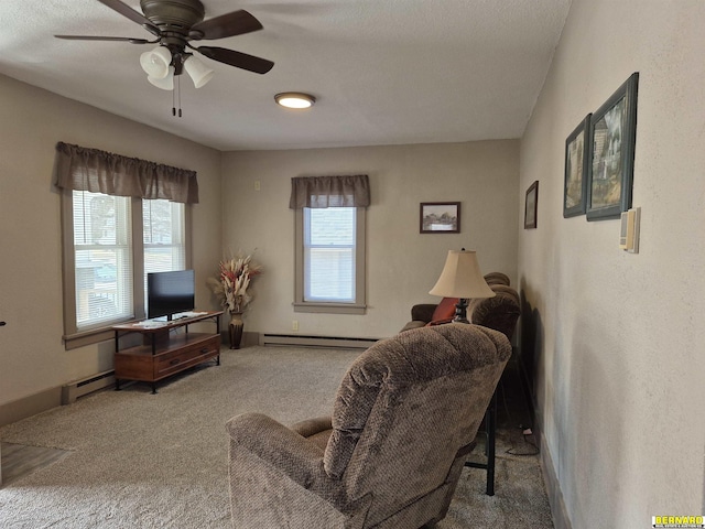 living area featuring baseboard heating, a baseboard heating unit, carpet flooring, ceiling fan, and baseboards