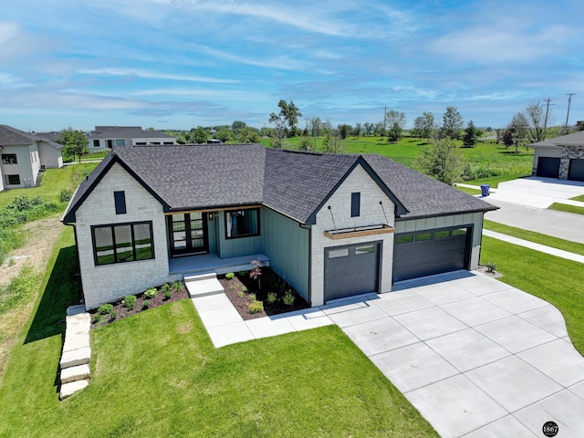 view of front of property featuring driveway, stone siding, roof with shingles, a front lawn, and board and batten siding