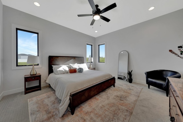 bedroom with light carpet, ceiling fan, baseboards, and recessed lighting