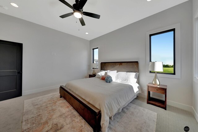 carpeted bedroom with multiple windows, baseboards, and a ceiling fan