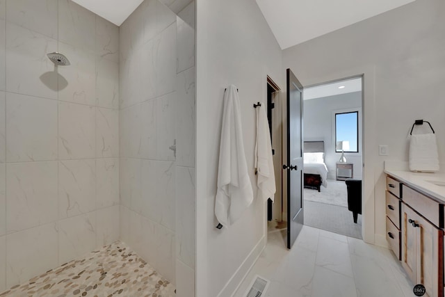 ensuite bathroom with visible vents, tiled shower, ensuite bathroom, marble finish floor, and vanity