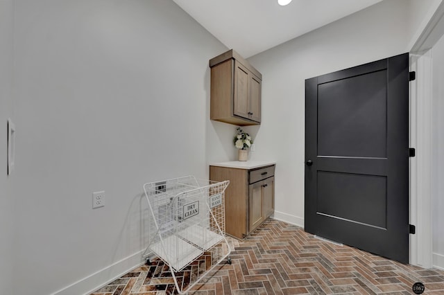 interior space with brick floor and baseboards