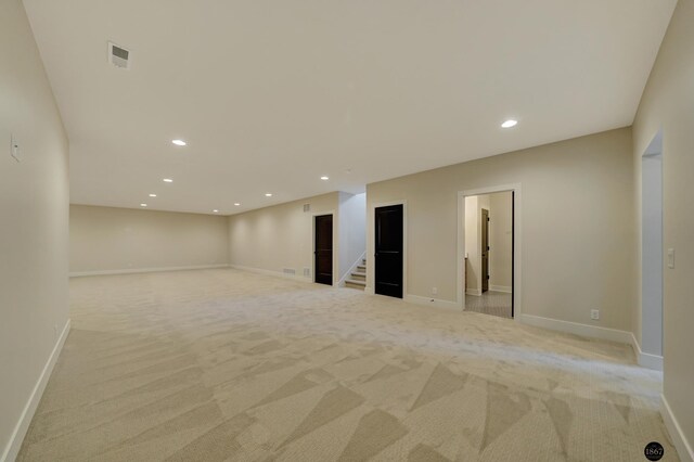 interior space with light carpet, stairs, visible vents, and recessed lighting