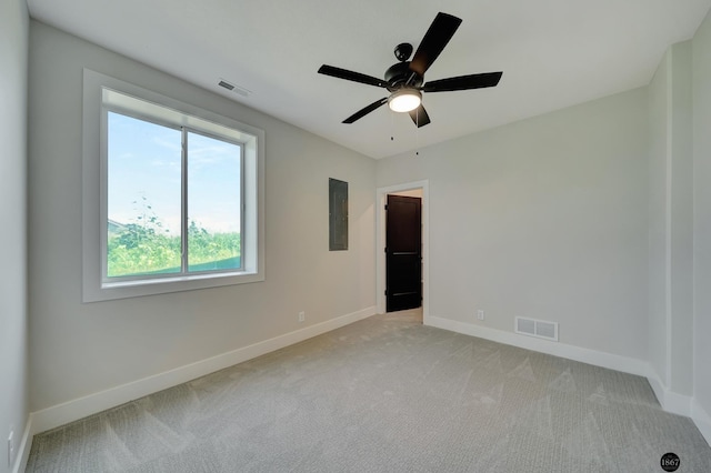 unfurnished room with a ceiling fan, light colored carpet, visible vents, and baseboards