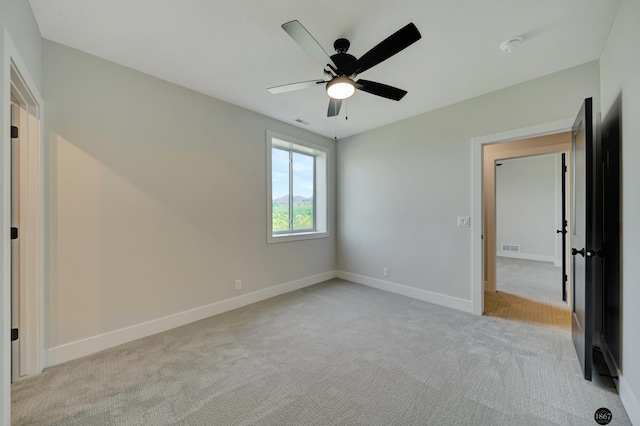 unfurnished bedroom featuring ceiling fan, visible vents, baseboards, and light colored carpet