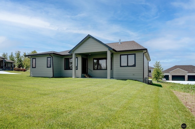 view of front of home featuring a front lawn and a shingled roof