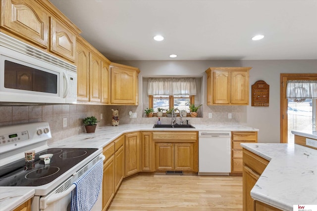 kitchen with recessed lighting, white appliances, a sink, light wood-style floors, and backsplash