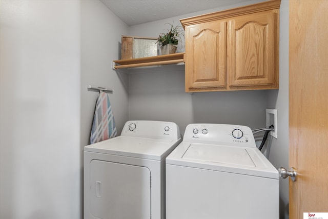 clothes washing area with washer and clothes dryer and cabinet space