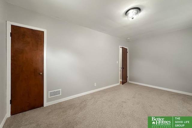 carpeted empty room featuring visible vents and baseboards