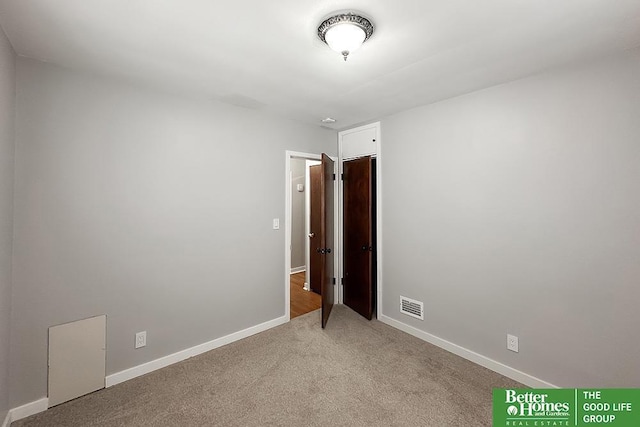 spare room with light carpet, baseboards, and visible vents