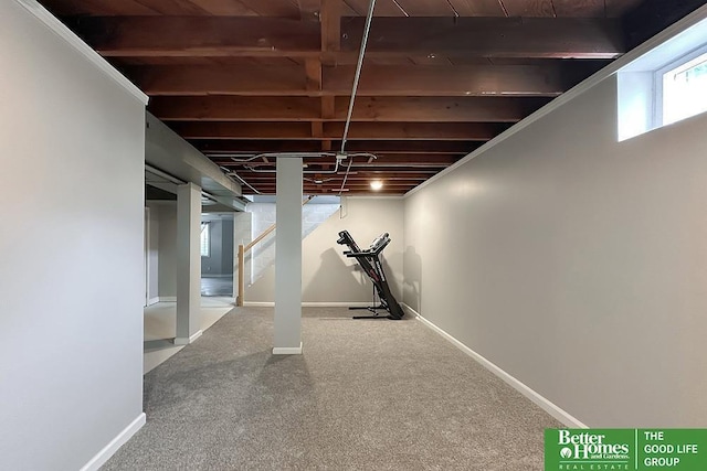 below grade area with carpet floors, stairway, and baseboards